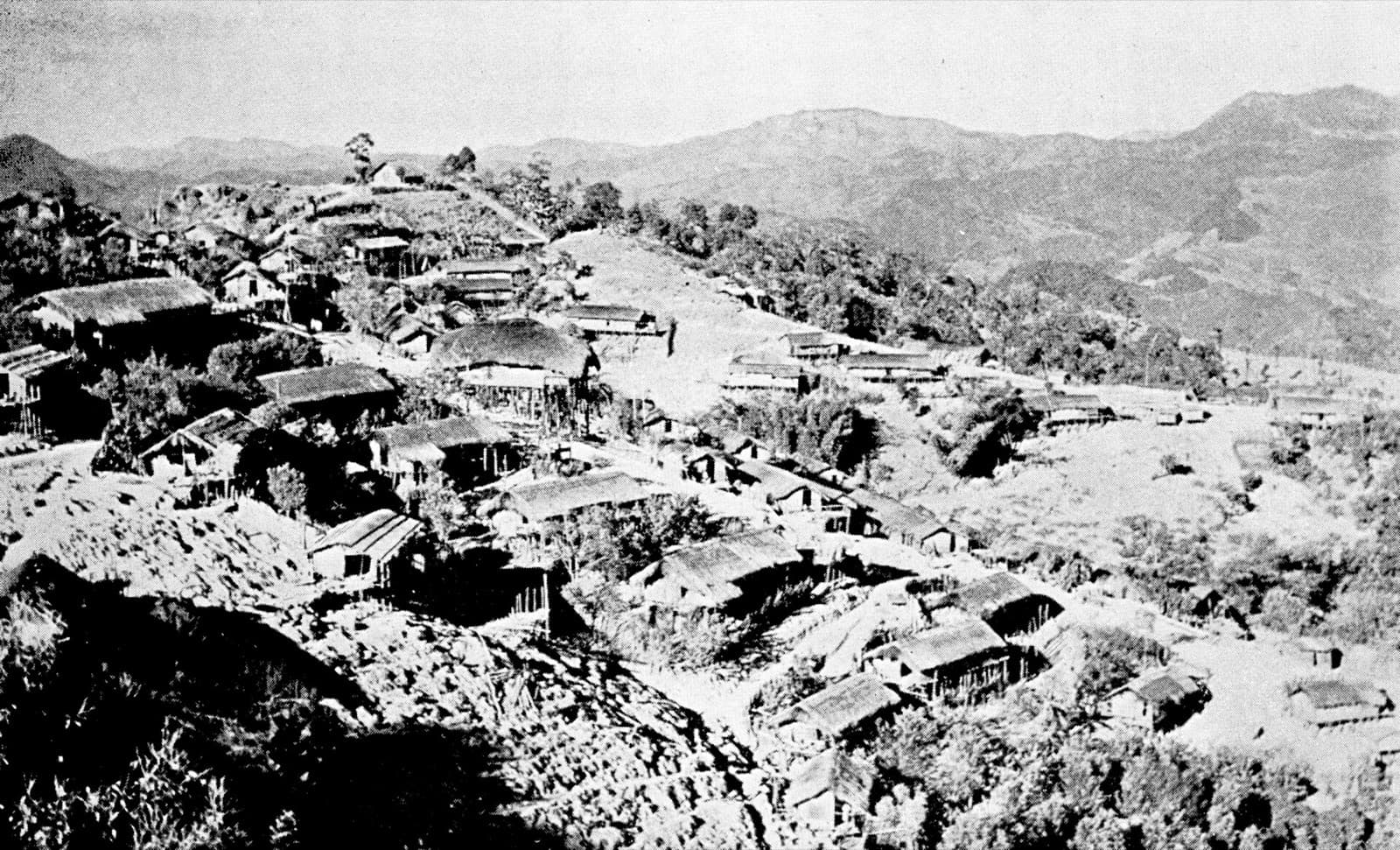 A Mizo hill village of thatched houses, in an archival photograph